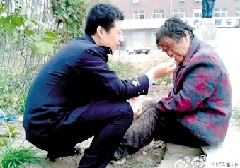迷途老人街頭暈倒 民警對(duì)其救助喂吃喂喝(圖)