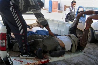 The bodies 
 of 
 three men are removed after they were killed in clashes between insurgents and armed local residents in the Dora section of Baghdad, Iraq, Tuesday, March 22, 2005. Iraqi Police were also involved in the firefight, witnesses said. [AP]