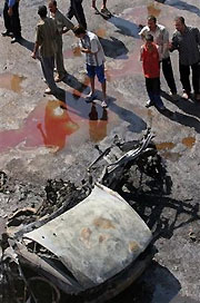 Iraqis gather at an explosion site in central Baghdad, Wednesday, Sept. 14, 2005.