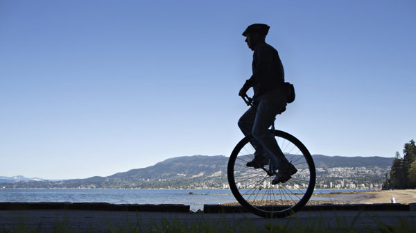 Unicyclist Dal rides along the seawall in Stanley Park on Earth Day in Vancouver, British Columbia April 22, 2013. Dal who turned 65 today has been riding his unicycle for about 10 years. Earth Day marked around the world