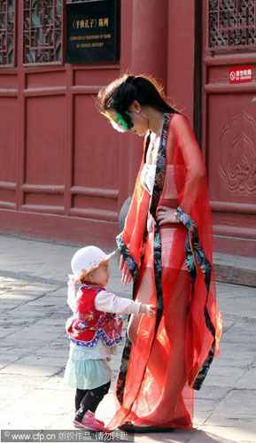 A child rushes towards a scantily-clad model daubed in body paint for a provocative campaign highlighting morals. The show, held at the Wen temple (Confucius temple) in Taiyuan, Shanxi province on May 15, was staged as a publicity stunt to spotlight what organizers say is a growing vulgar culture within society. Most tourists at the site thought the stunt was in bad taste and an affront to traditional Chinese culture and the legacy of Confucius. Vulgar morality challenges traditional culture