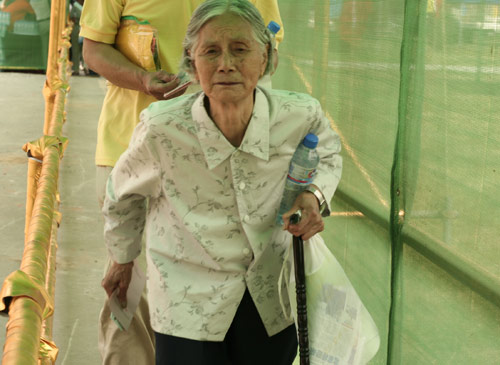An aged woman waits to cast a vote on the demolishment and reconstruction of old buildings in Juixiaqiao Sub-district in Beijing, June 9, 2007. Local government and the real estate developer jointly organize the vote on Saturday to see if majority residents of over 5000 families accept the new compensation policy after failed attempts to reach an agreement through other ways. Both notary officials and supervisors are invited to monitor the vote that runs from 9 a.m. to 9 p.m. at six ballot booths. [Sun Yuqing/www.midnightarchive.com]