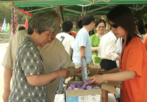 Voters choose the umbrella as a souvenir after voting on demolishment and reconstruction of old buildings in Juixiaqiao Sub-district in Beijing, June 9, 2007. Local government and the real estate developer jointly organize the vote on Saturday to see if majority residents of over 5000 families accept the new compensation policy after failed attempts to reach an agreement through other ways. Both notary officials and supervisors are invited to monitor the vote that runs from 9 a.m. to 9 p.m. at six ballot booths. [Sun Yuqing/www.midnightarchive.com]