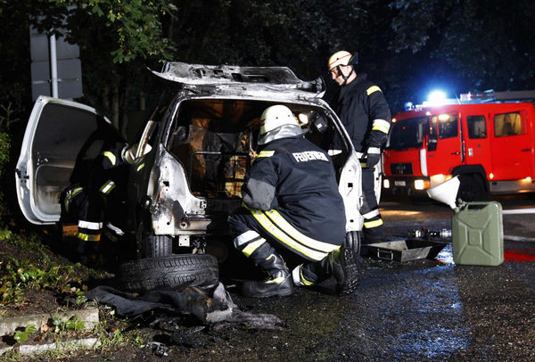 Fire fighters inspect a burnt car in the Koepenick district of Berlin August 19, 2011. Arson attacks on cars surge in Berlin