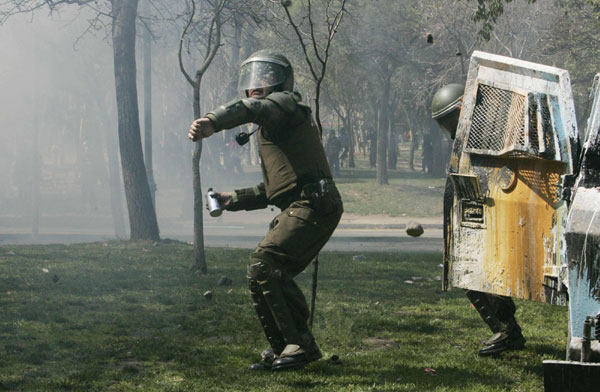A riot policeman prepares to throws a tear gas canister at demonstrators during a student rally against the government's public education system in Santiago city September 22, 2011. Chile: Students riot demanding education reform
