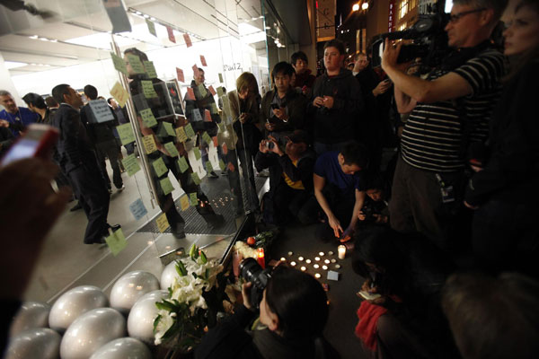 Mourners gather around an impromptu shrine in memory of Apple co-founder Steve Jobs outside the Apple Store in San Francisco, California October 5, 2011. The world mourns Steve Jobs