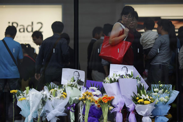 Flowers in memory of Apple co-founder Steve Jobs are placed outside an Apple Store in downtown Shanghai October 6, 2011. The world mourns Steve Jobs