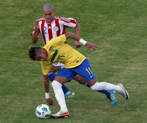 Brazil's Neymar (near) is challenged by Paraguay's Dario Veron during their match in the first round of the Copa America soccer tournament in Cordoba, July 9, 2011. Brazil draws Paraguay 2-2 in Copa America