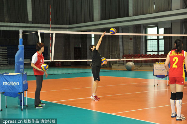 Lang Ping, left, head coach of Guangdong Evergrande Women's Volleyball Club, gives guidance to players before a farewell ceremony in Guangzhou, Guangdong province, on May 8, 2013. Evergrande holds farewell ceremony for Lang Ping