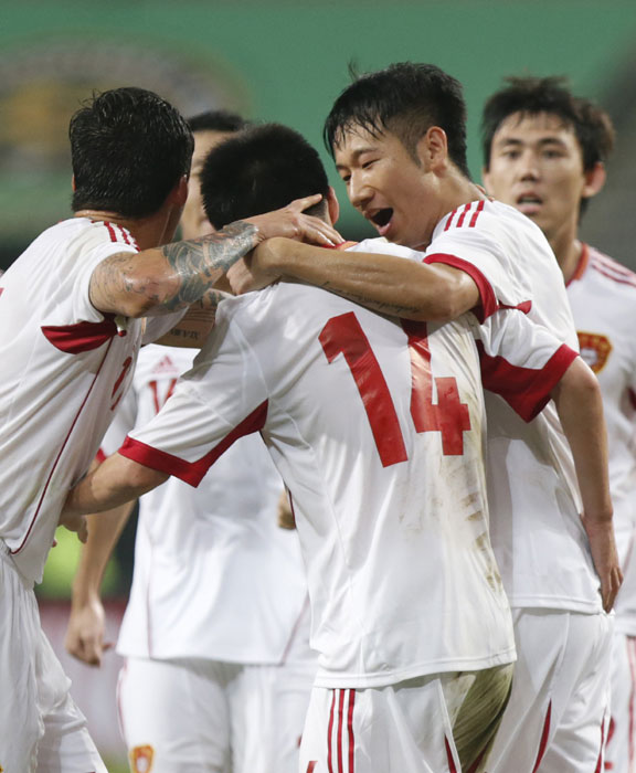 China's Sun Ke (14) celebrates with teammates after scoring a goal against Japan during the East Asian Cup soccer championship match at the Seoul World Cup stadium in Seoul, July 21, 2013. Holders China tie Japan 3-3 in East Asian Cup opener